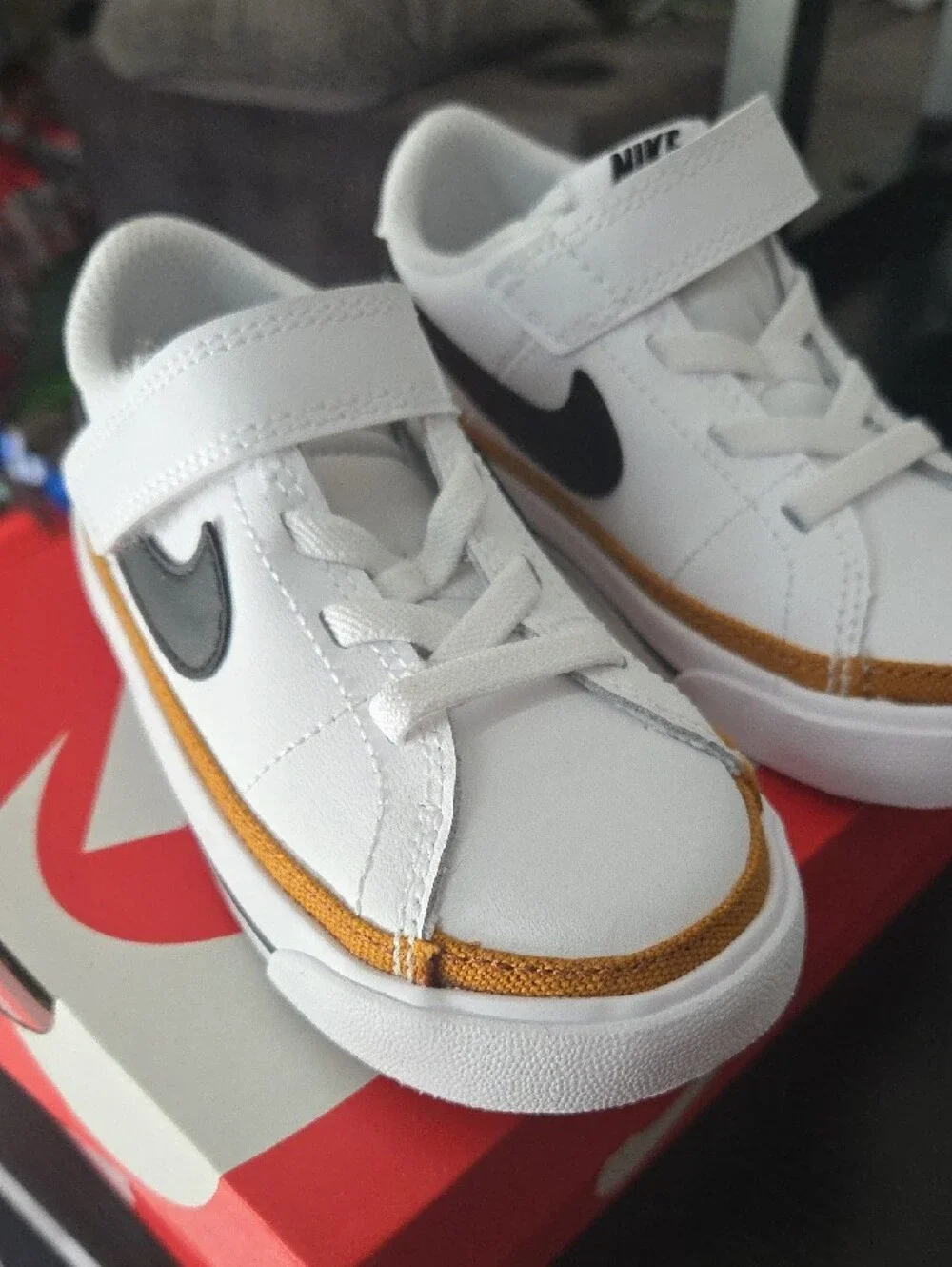 Nike Kids White Sneakers with Black Swoosh and Gold Accent